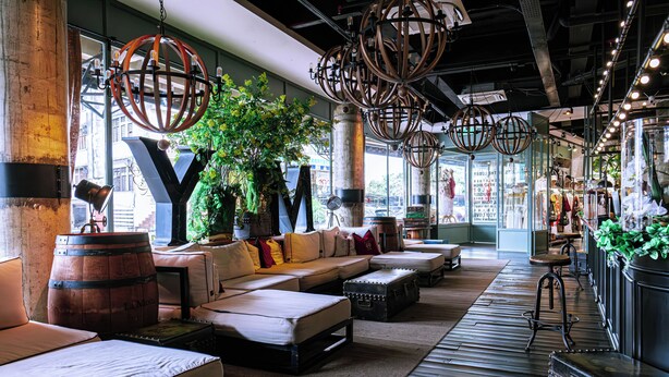 A modern lounge area with a sofa set, a bar stool, and a large wooden barrel. - M Boutique Hotel (Ipoh)