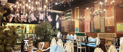 Un interior de restaurante con candelabros ornamentados, paneles de madera y muebles de estilo chino tradicional.