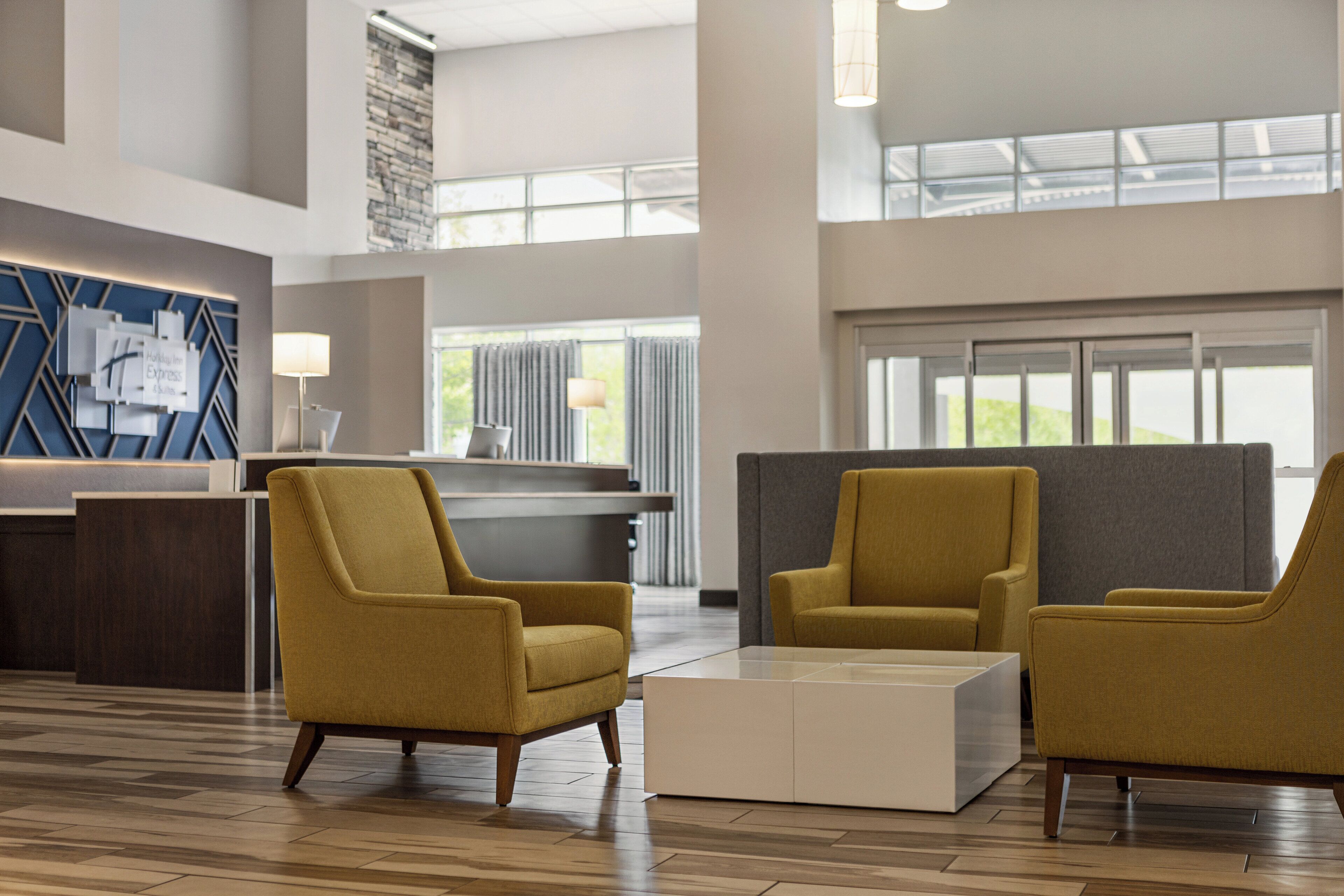 A spacious lobby with a reception desk, two armchairs, and a coffee table.