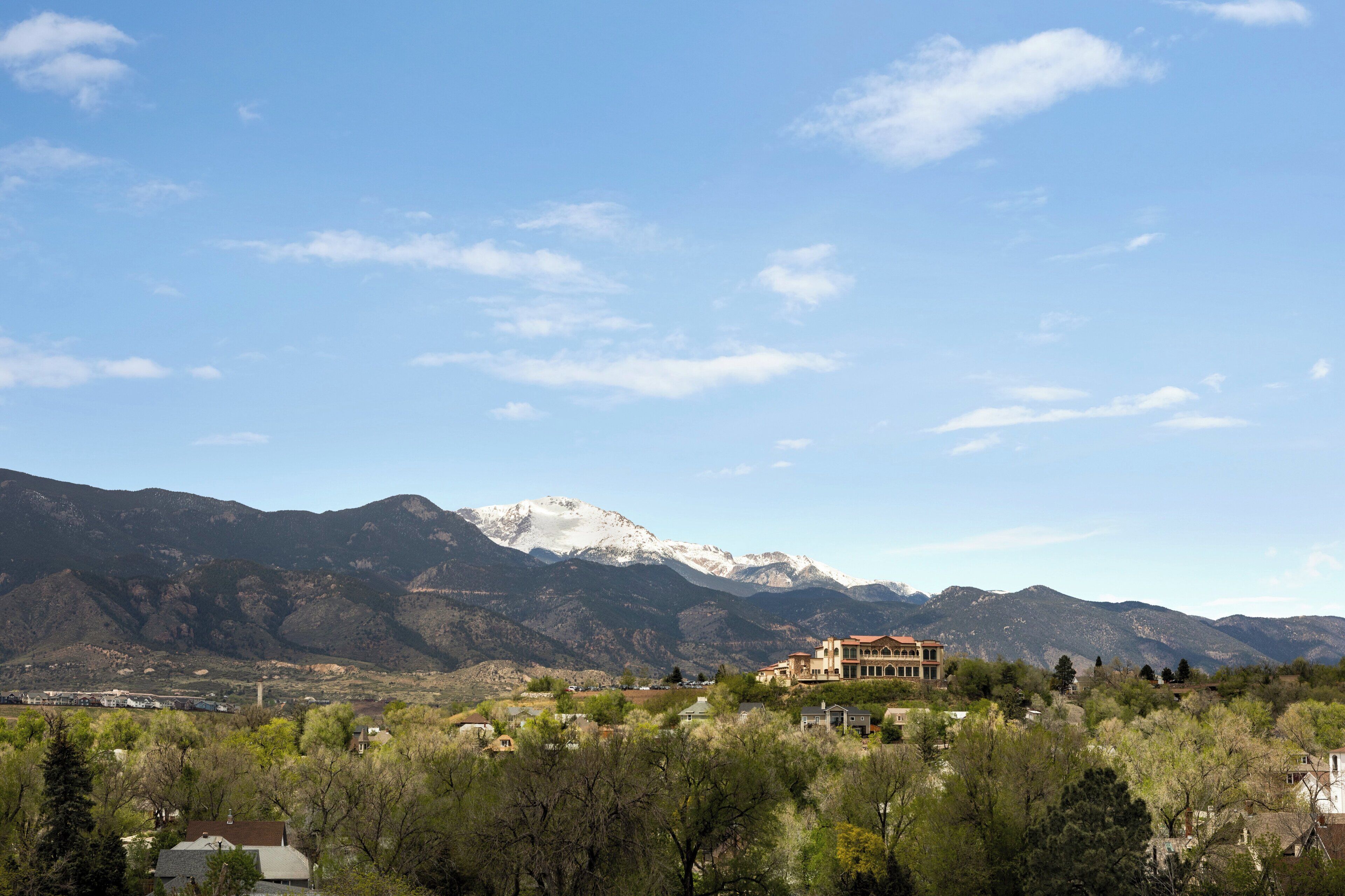 Un paisaje montañoso con una casa grande al frente.