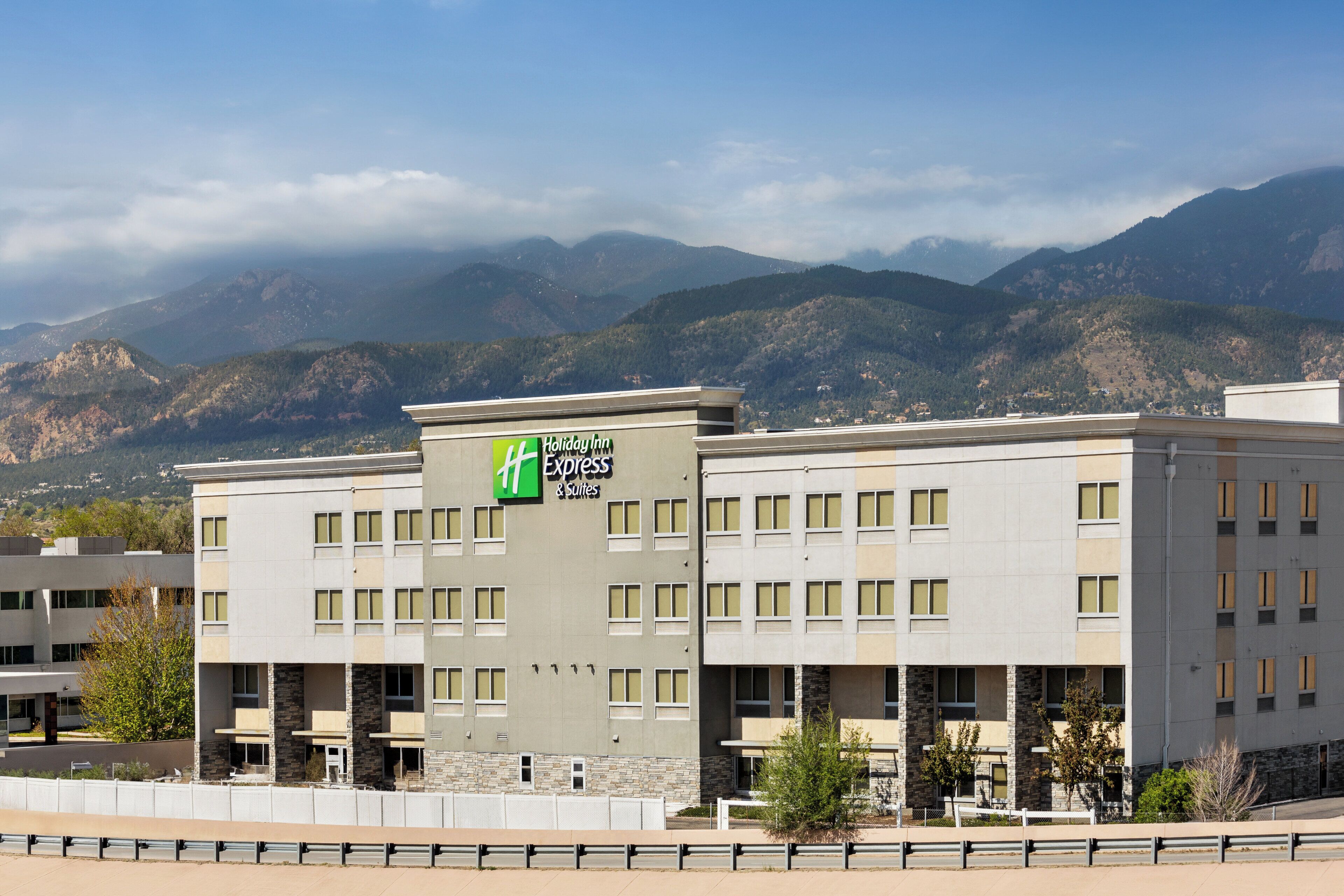 A Holiday Inn Express building with a view of mountains in the background.