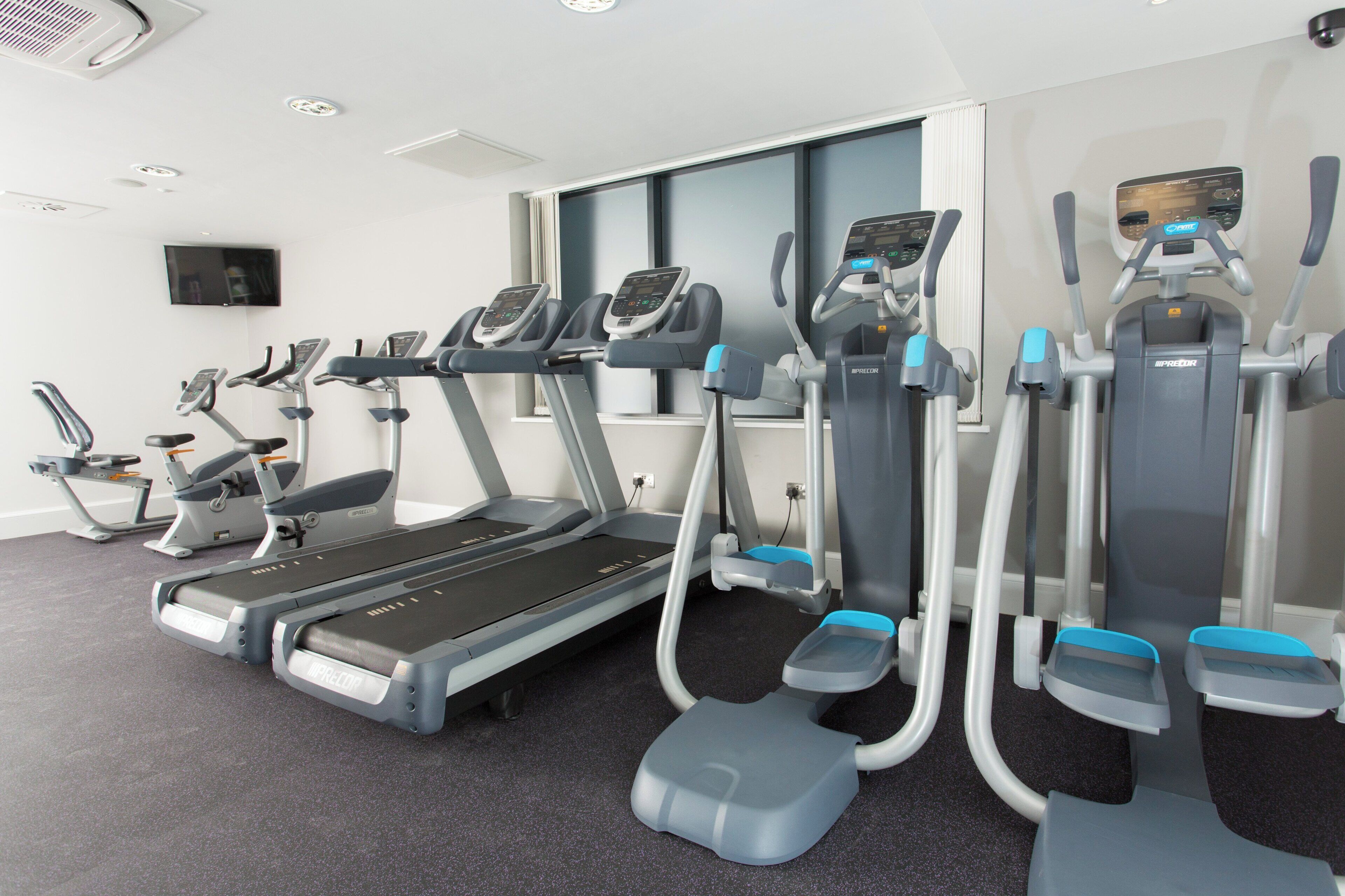 A gym with treadmills, ellipticals, and a stationary bike.