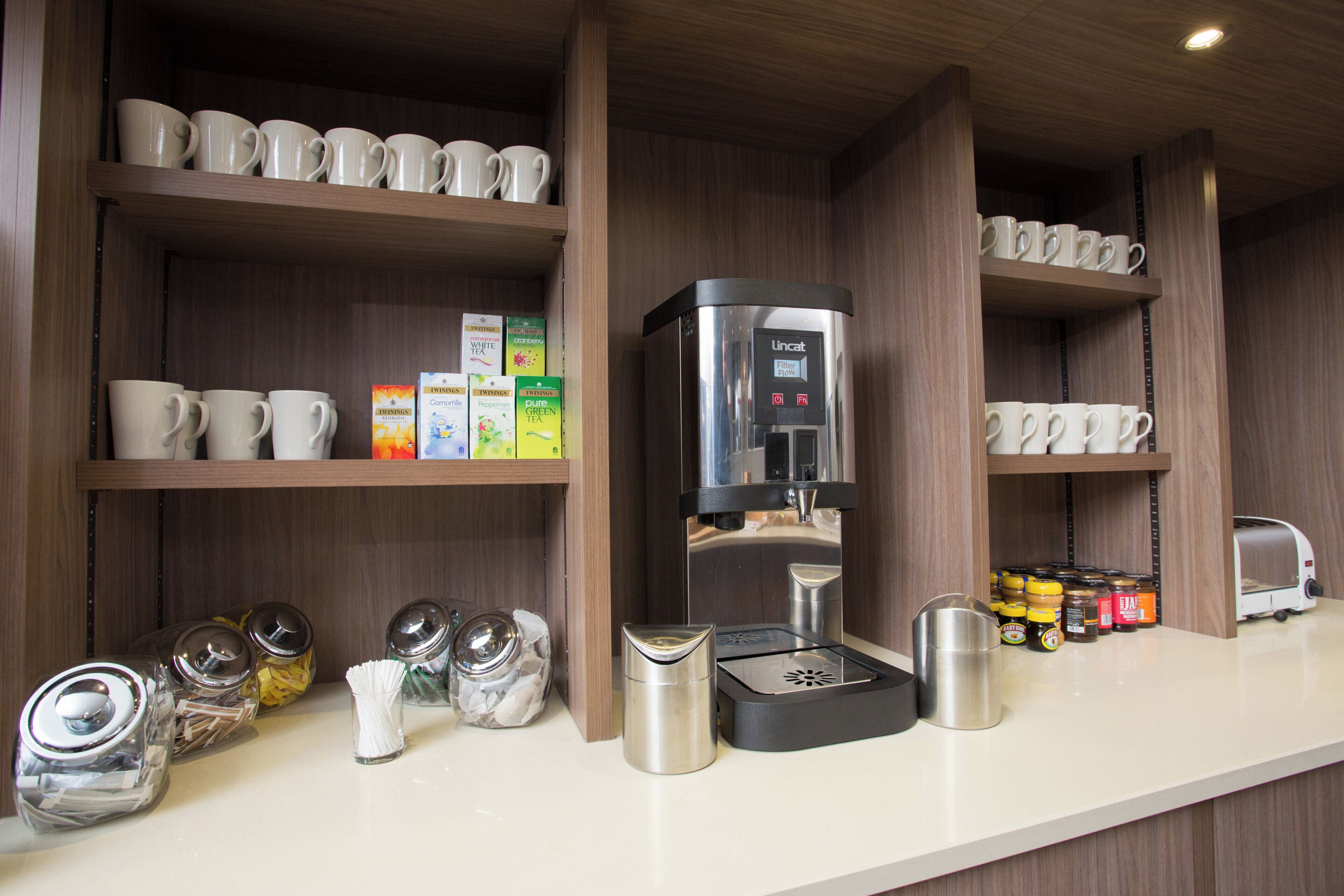 Eine Kaffeestation mit Kaffeemaschine, Teesorten und verschiedenen Zusätzen.