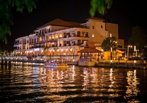 Un hôtel situé au bord de l’eau, doté de nombreux balcons, d’un quai pour bateaux et d’un belvédère.