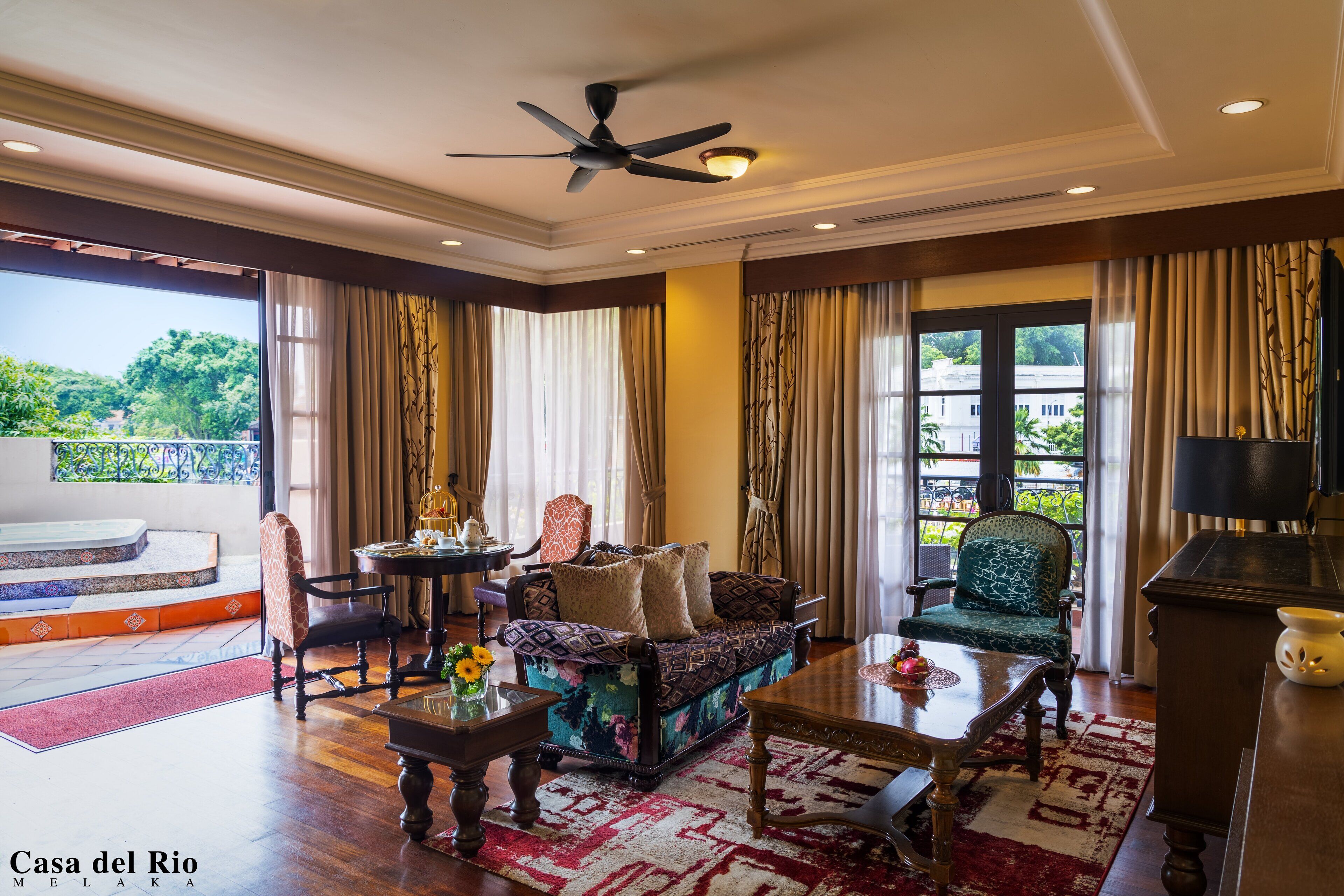A spacious living room with a sofa, chairs, a coffee table, and a balcony with a view.