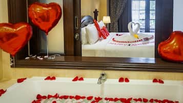 Een aparte badkuip en douche, een diep bad, een regendouche