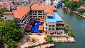 A hotel with a central courtyard, a swimming pool, and a river view. - Casa del Rio Melaka (Malacca City)