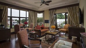 A spacious living room with a large window, a ceiling fan, and a view of the city. - Casa del Rio Melaka (Malacca City)