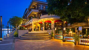 Un hôtel avec vue sur le front de mer, une terrasse et une entrée bien éclairée.
