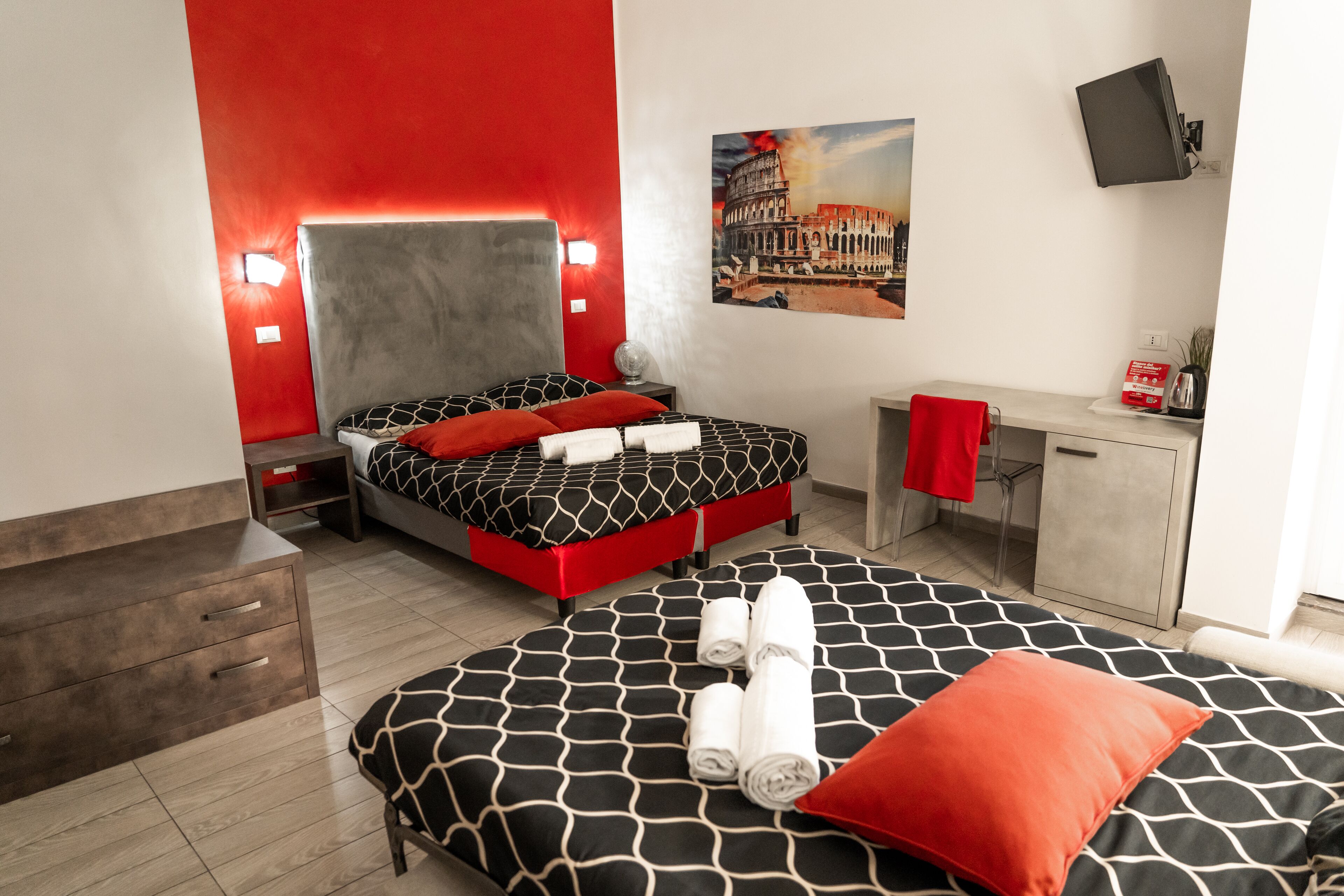 A hotel room with a bed, a desk, and a chair.