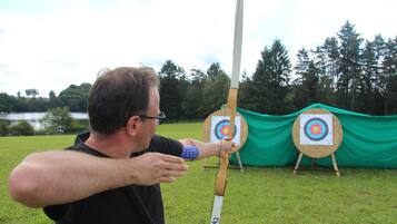 A man aiming a bow at a target.