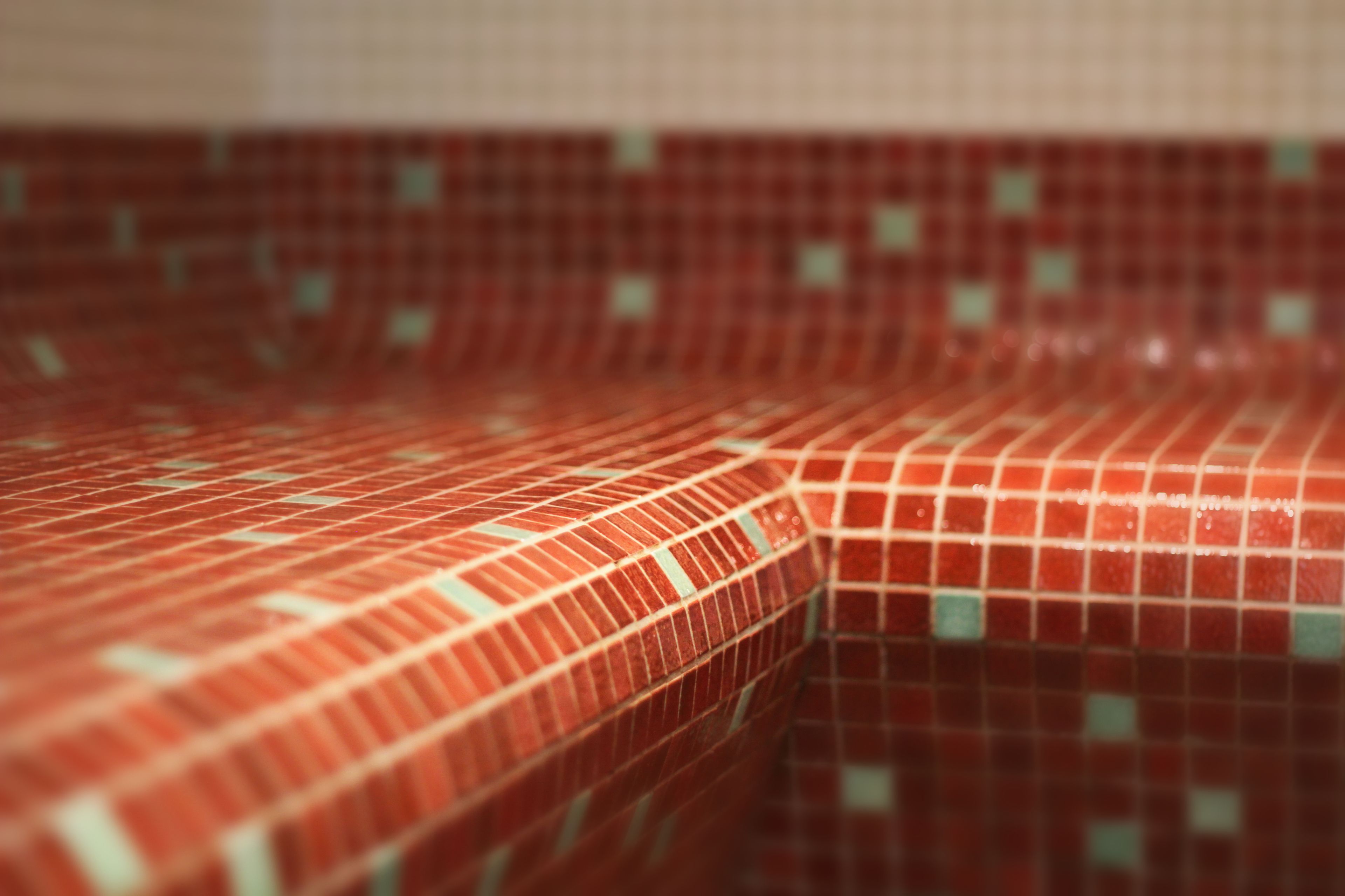 A close-up of a tiled wall with a red and green mosaic pattern.