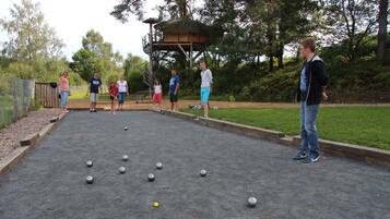 Una cancha de shuffleboard con jugadores y bolas.