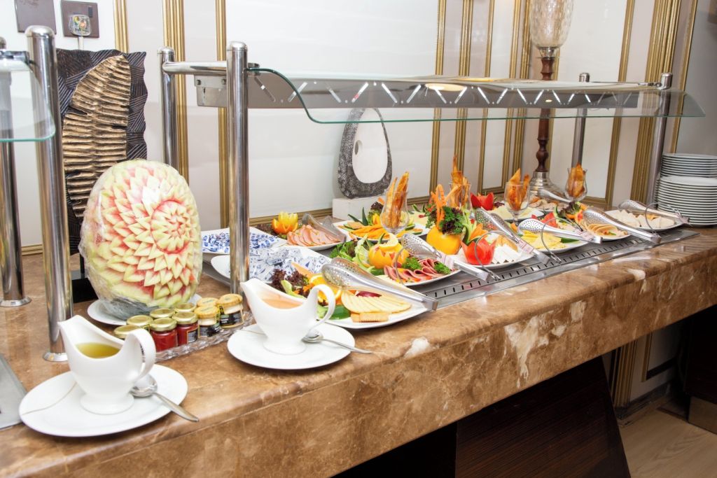 A buffet setup with various food items and condiments.
