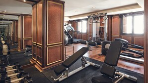 A gym with exercise equipment, a bench press, and a mirrored wall. - Dallah Taibah Hotel (Madinah)