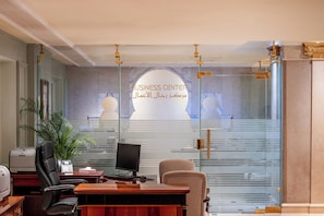 Et moderne kontor med en glasvæg, der viser teksten 'BUSINESS CENTER' og arabisk skrift.
