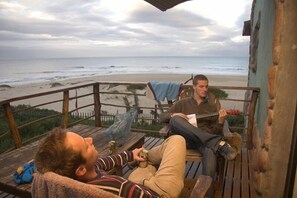 Um deck de madeira com vista para a praia e o oceano.