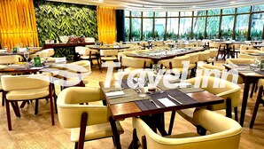 A spacious restaurant with multiple dining tables and chairs, large windows with a view of greenery, and a modern interior design. - Travel Inn Premium Flats Paulista Wall Street  (São Paulo)
