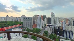 A cityscape with high-rise buildings, a prominent tower, and a green area in the foreground. - Travel Inn Premium Flats Paulista Wall Street  (São Paulo)