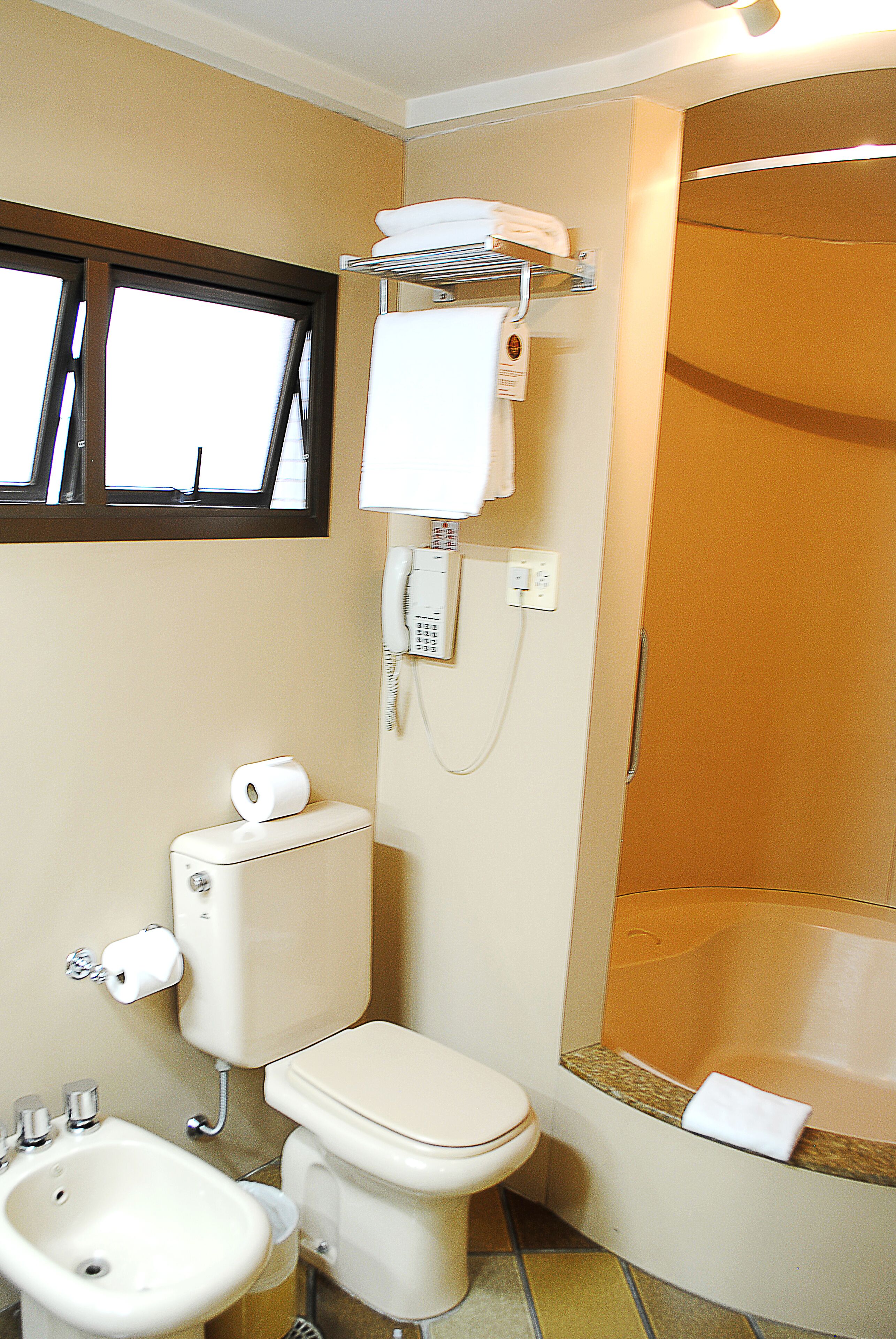 A bathroom with a toilet, bidet, sink, and a bathtub.