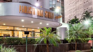 A modern building with a curved entrance and a sign that reads "PAULISTA MAIN STREET". - Travel Inn Premium Flats Paulista Wall Street  (São Paulo)