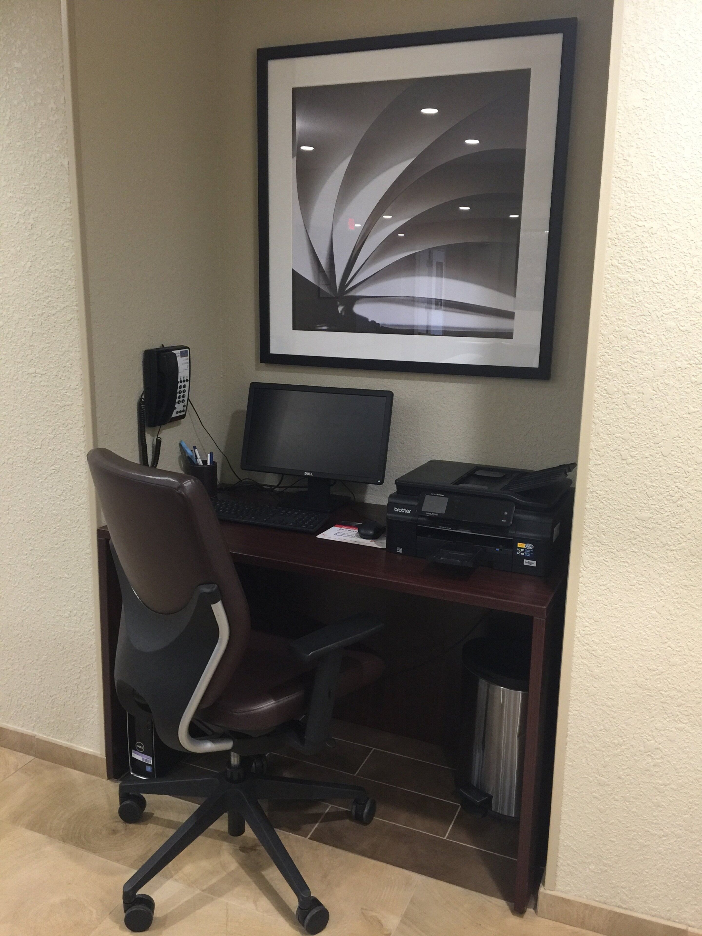 A desk with a computer, printer, and phone.