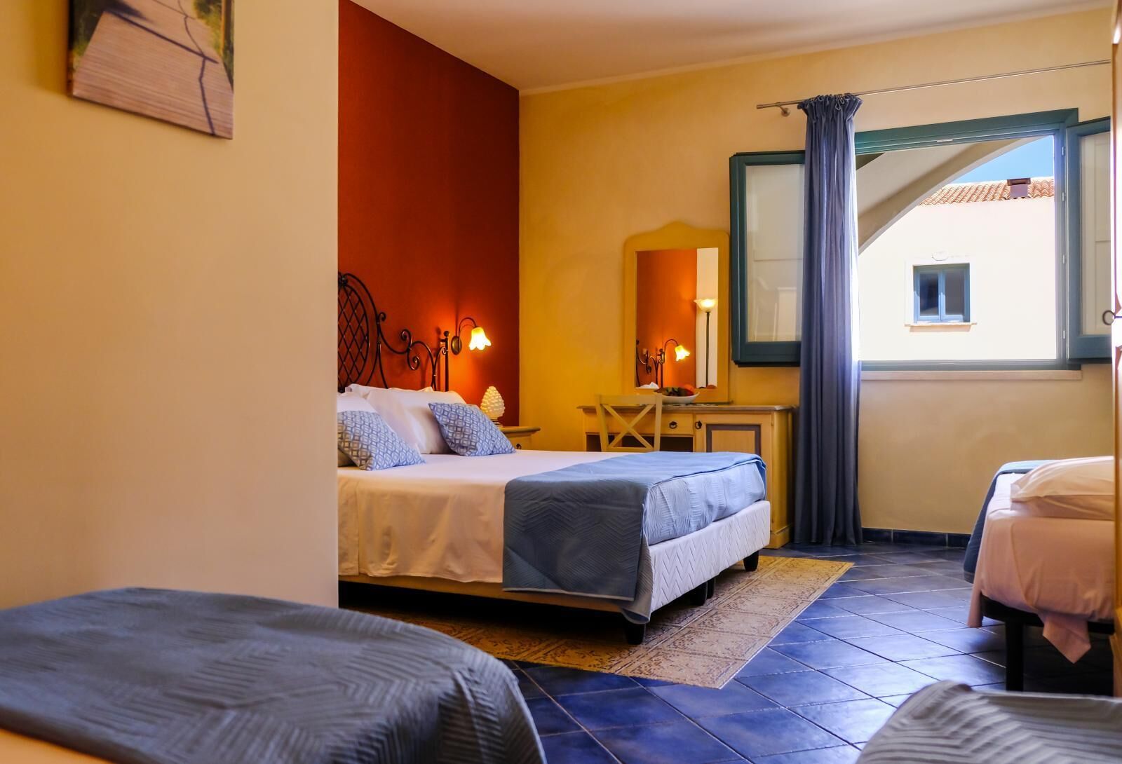 A hotel room with a bed, a desk, a chair, and a window with curtains.