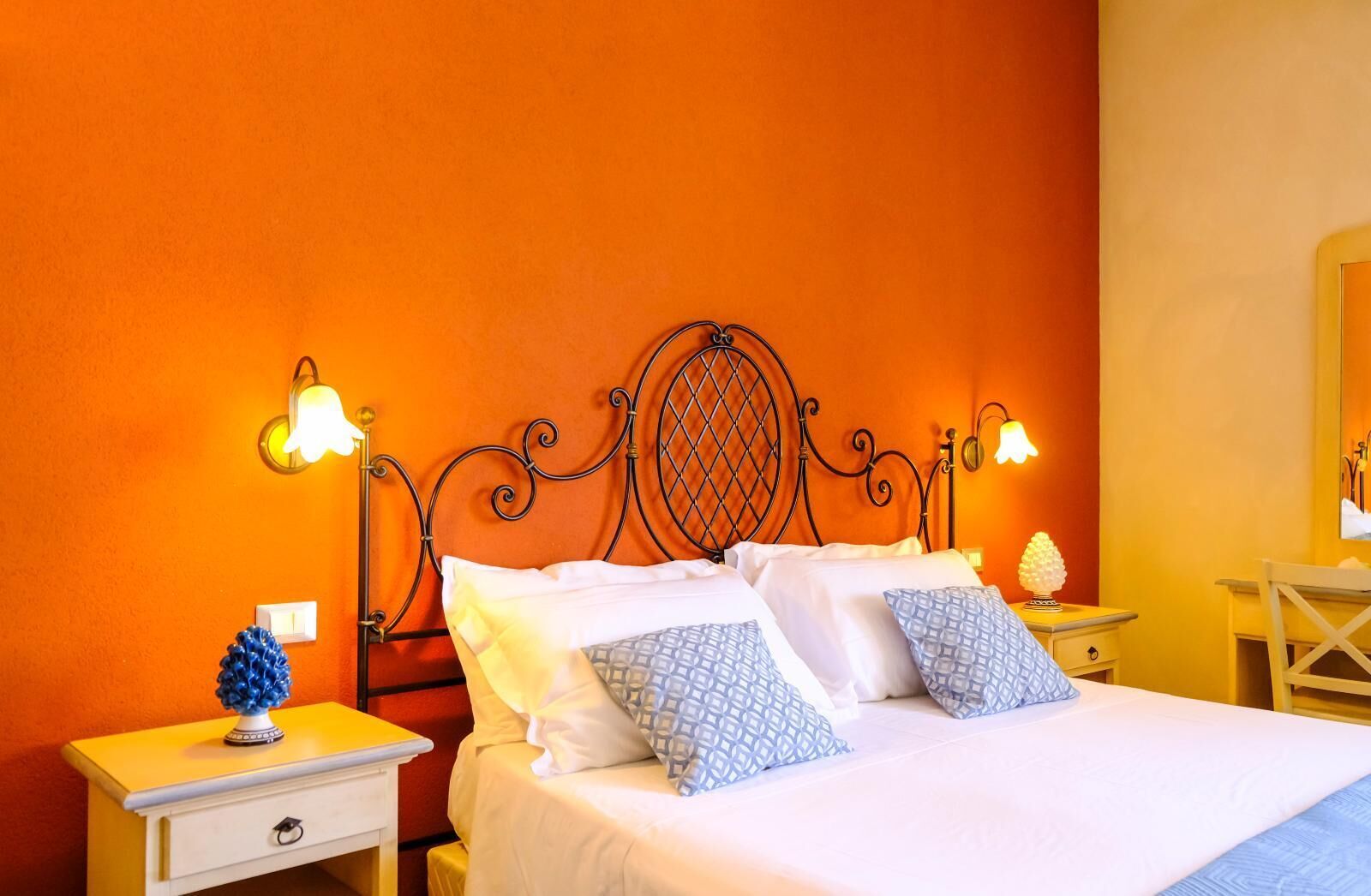 A hotel room with a bed, two bedside tables, and a nightstand.