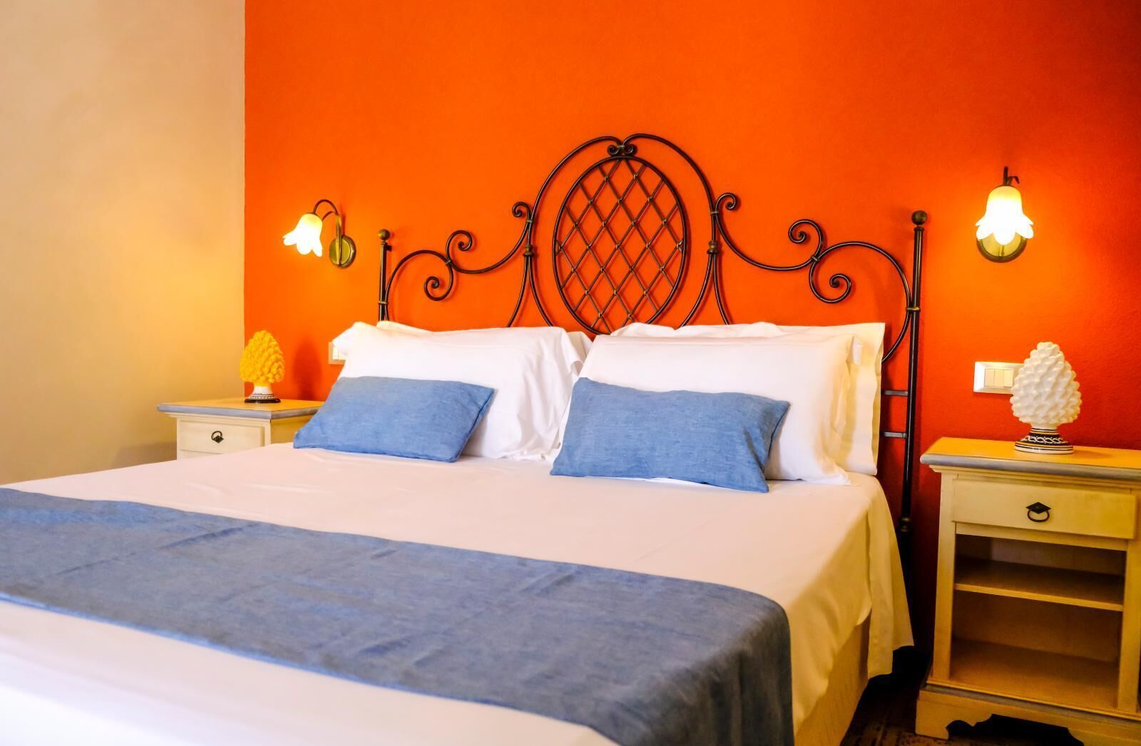 A bed with a headboard, two pillows, a bedside table, and a nightstand with a lamp.