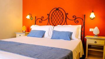 A bed with a headboard, two pillows, a bedside table, and a nightstand with a lamp.