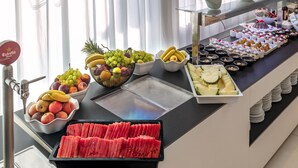 Een buffet met verschillende soorten fruit en desserts.