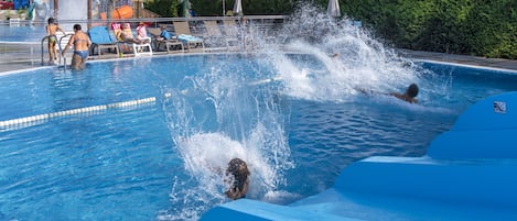 Una piscina al aire libre, sombrillas, tumbonas