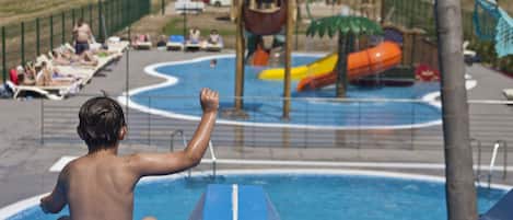 Una piscina al aire libre, sombrillas, tumbonas