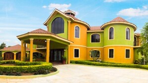 A large, multi-story house with a curved roof and a spacious front yard. - Milbrooks Villa and Retreat (Montego Bay)