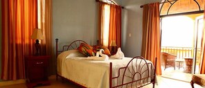 A bedroom with a bed, a nightstand, and a window with curtains.