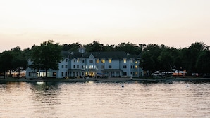 A waterfront property with a large building featuring multiple levels and a dock extending into the water. - Oakwood Resort (Syracuse)