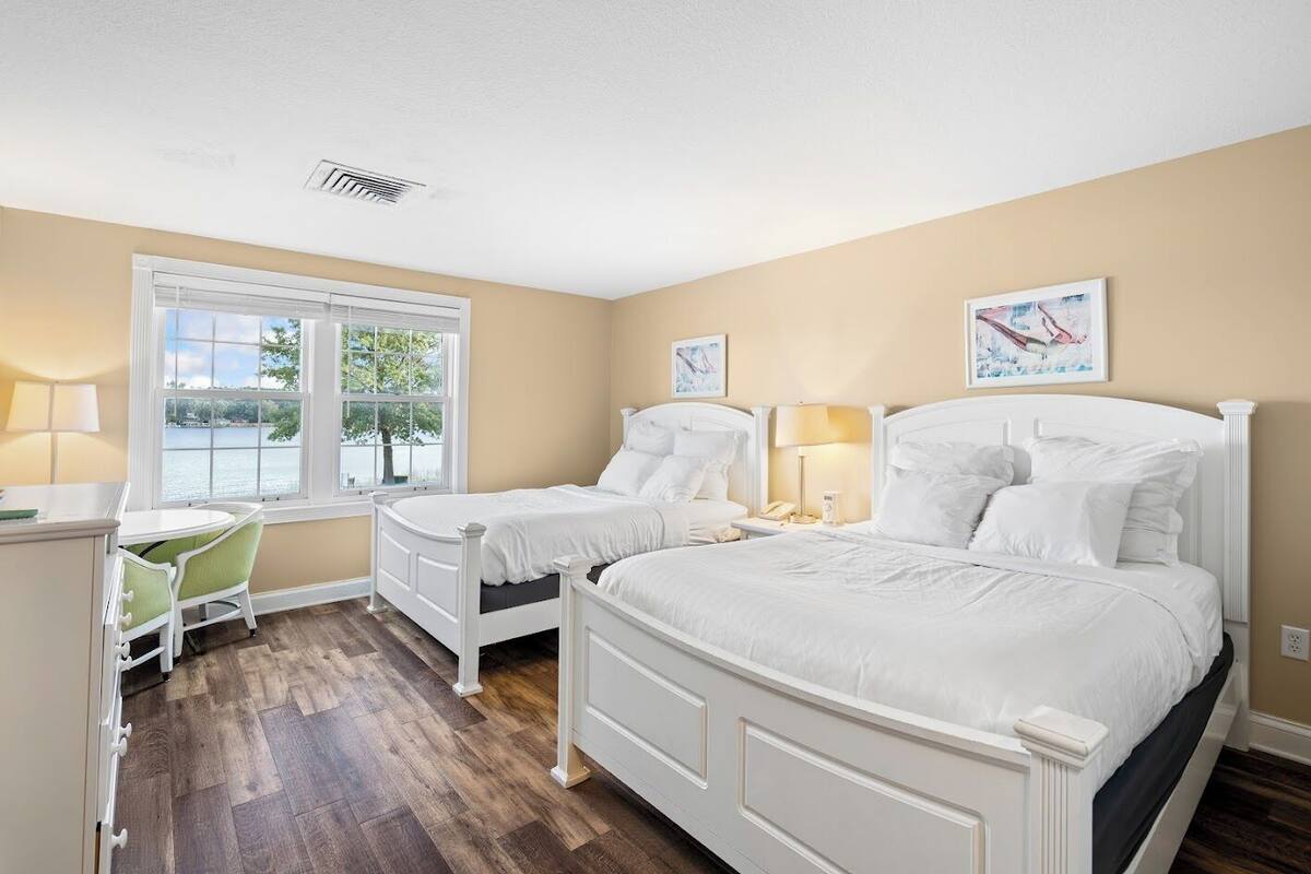 A bedroom with two single beds, a desk, and a chair.