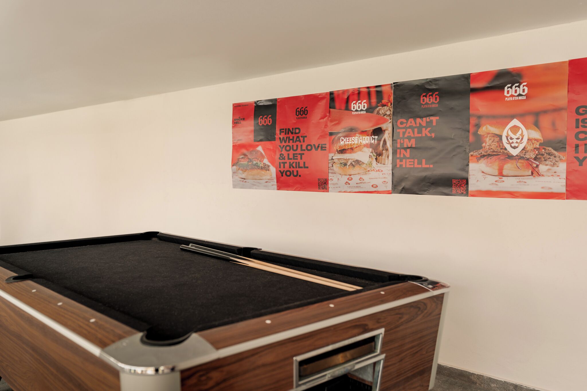 A pool table in a room with a white wall.