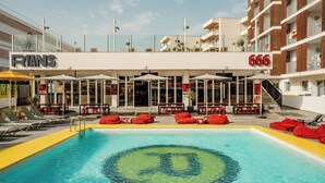 Un hotel con piscina, mobiliario exterior y un cartel que dice "RYANS 666".