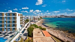 Un hotel frente al mar, con varios pisos, piscina y vistas al océano.