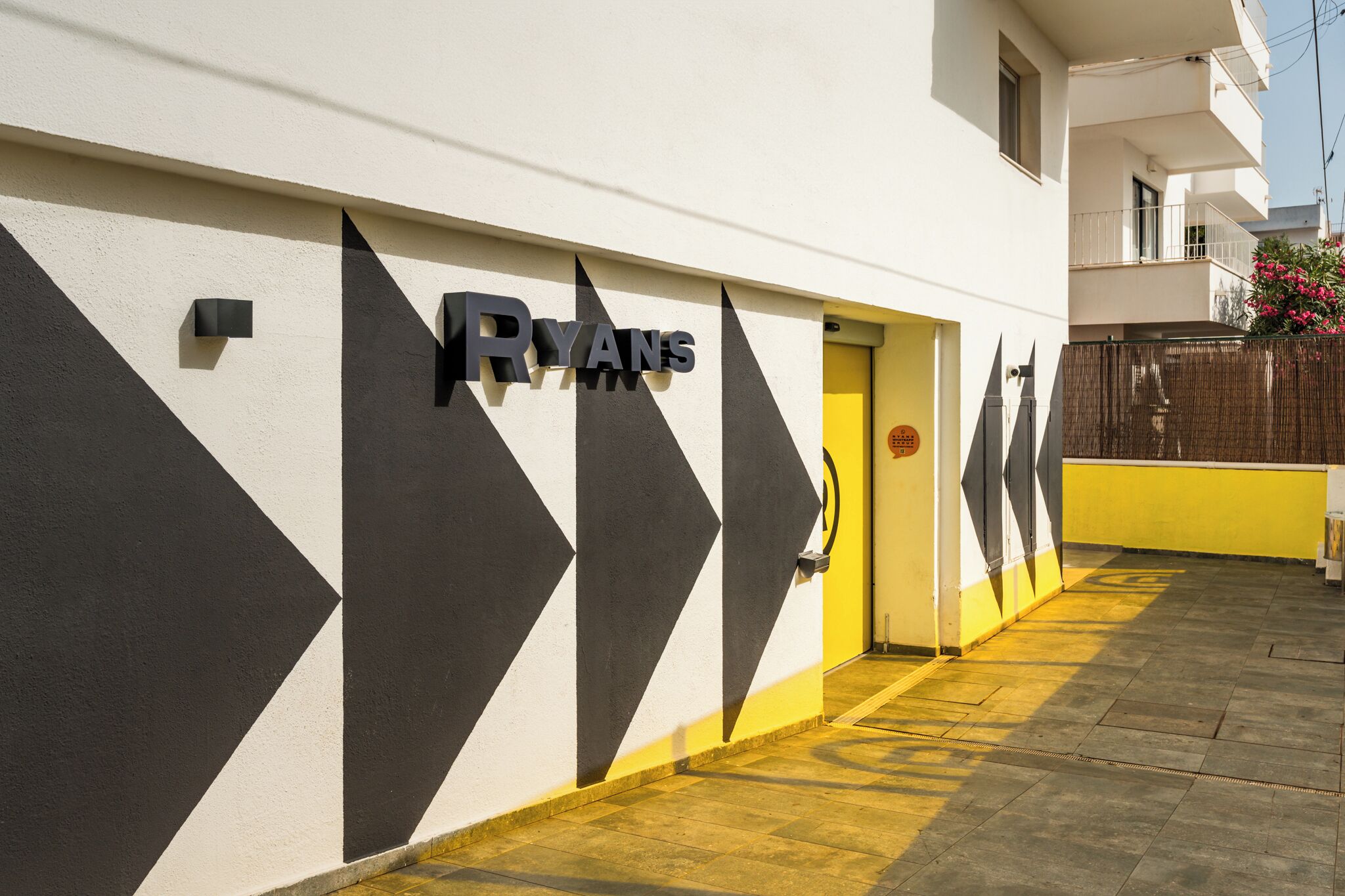 A building with a geometric facade and a yellow door.