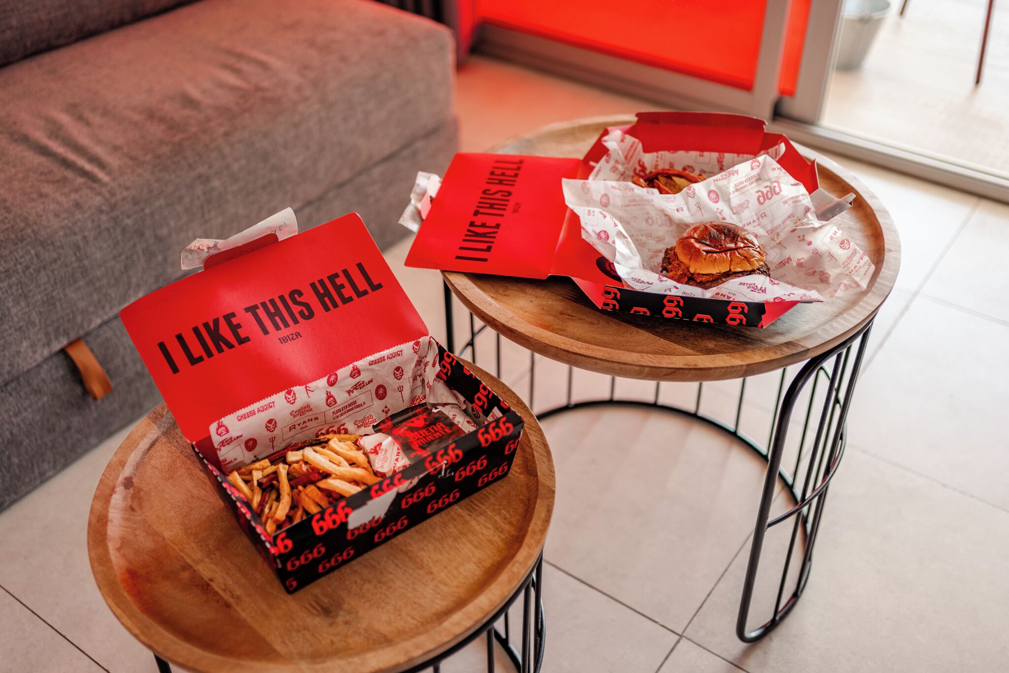 Two tables with food containers and napkins.