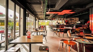 Un restaurante moderno con barra, amplios ventanales y diferentes opciones de asientos.