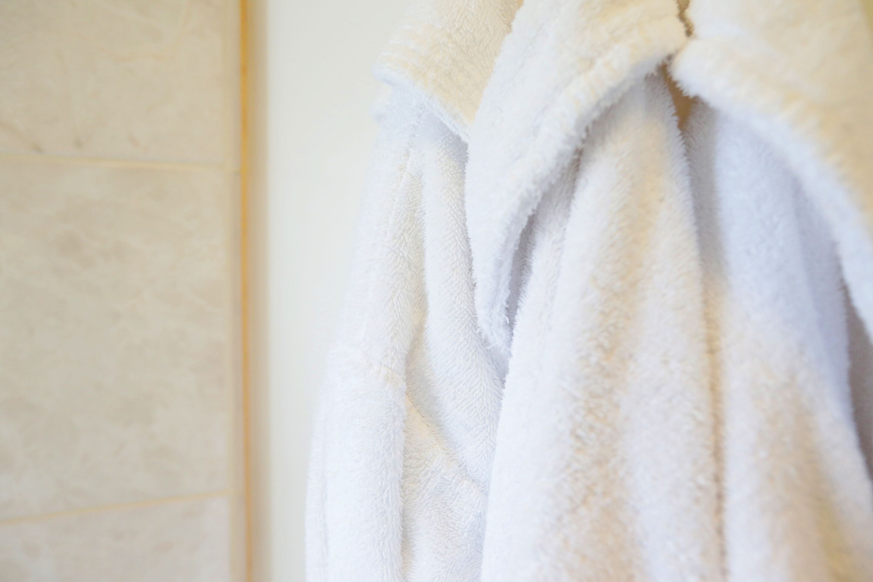 A white towel hanging on a wall.