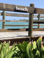 Una terraza de madera con un letrero que dice "playa" y vista al océano.