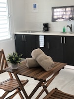 Una mesa de comedor de madera con dos toallas color beige y una planta en maceta.