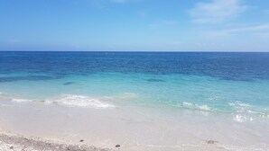 Una playa con aguas turquesas cristalinas y una orilla arenosa.