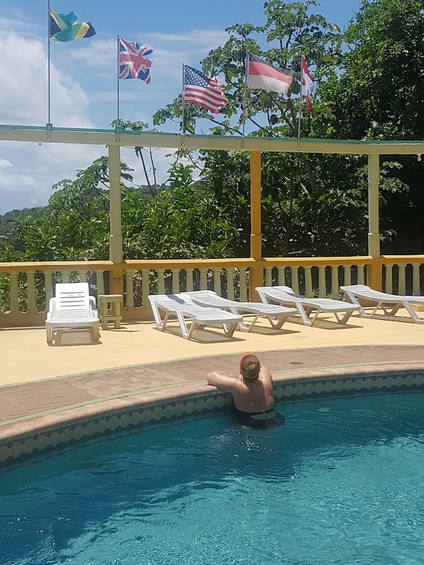 Una piscina al aire libre, sombrillas, tumbonas