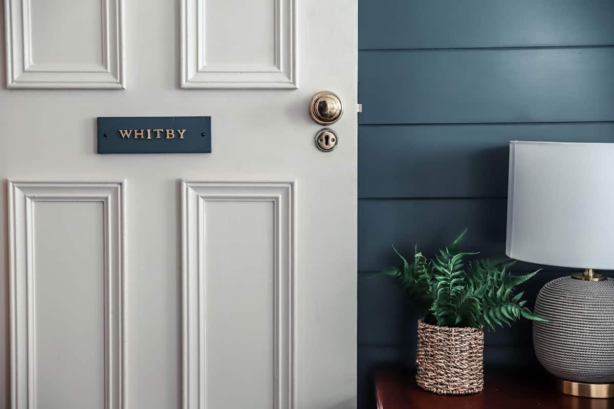 A white door with a nameplate reading "WHITBY" and a keyhole.