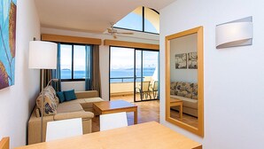 A modern hotel room with a balcony, a sofa, a table, and a large mirror. - Monéa Royal Mónica (Yaiza)
